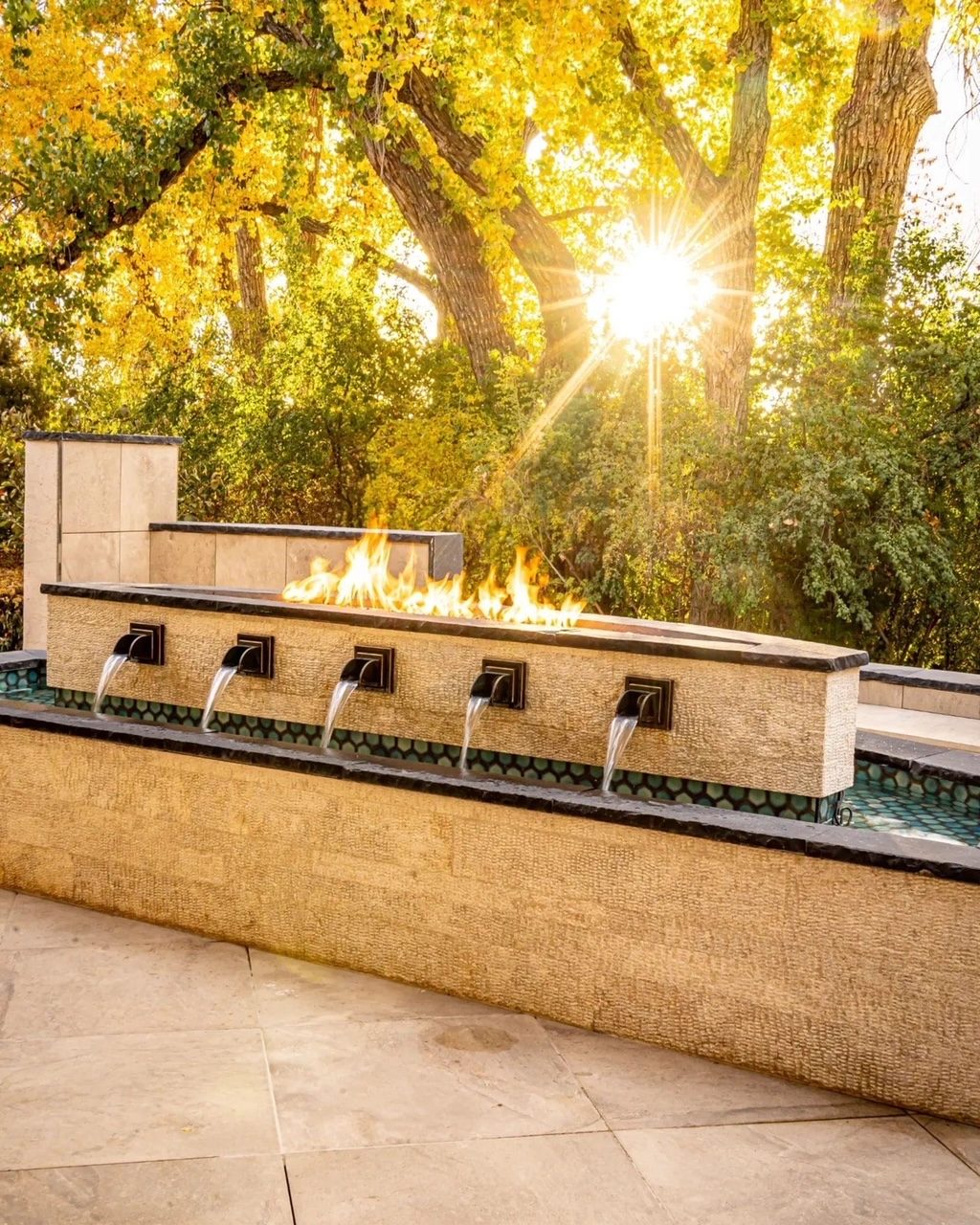 Hilltop fire and water feature at sunset